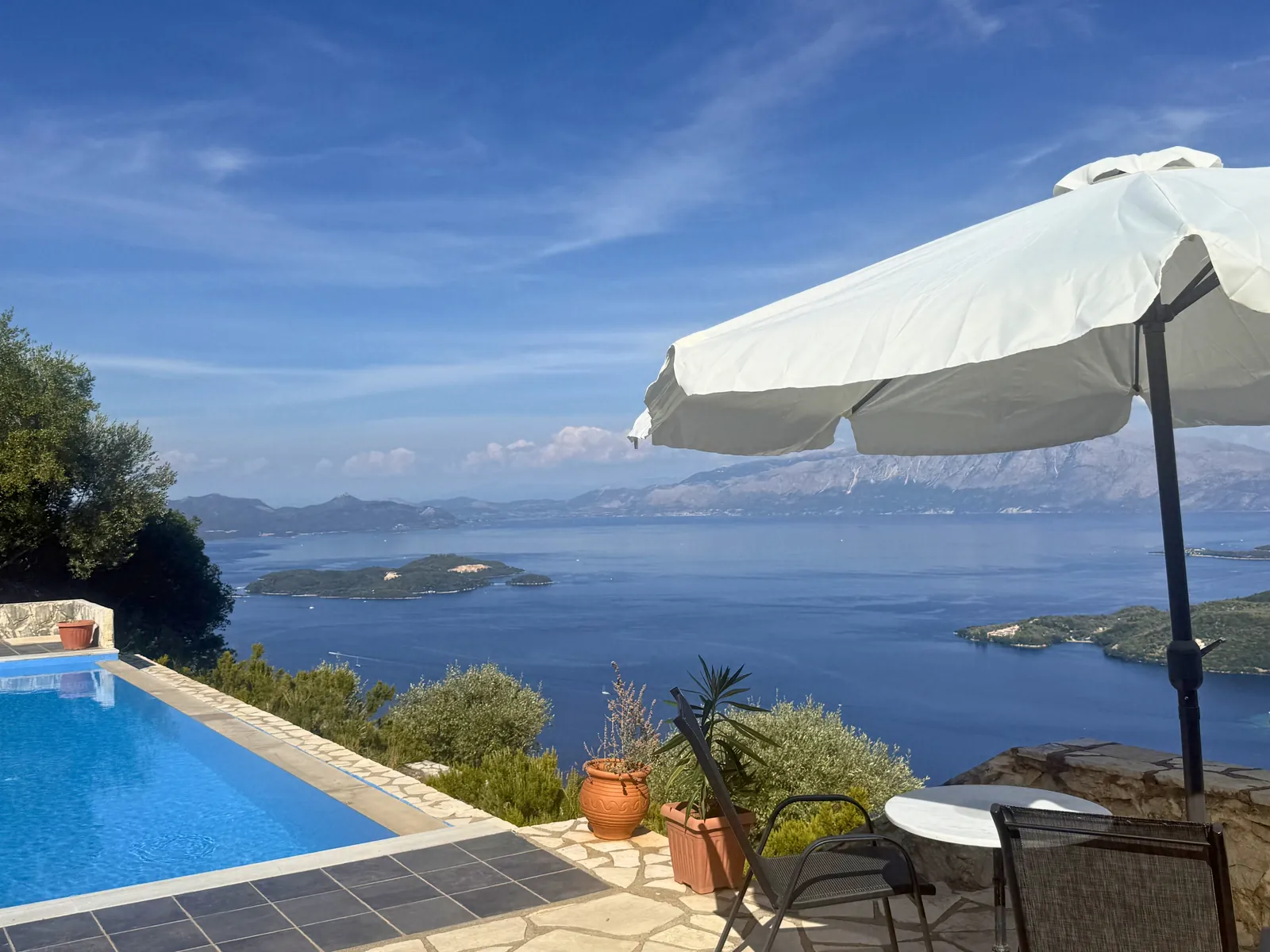Τραπέζι δίπλα στην πισίνα, κάτω από την ομπρέλα